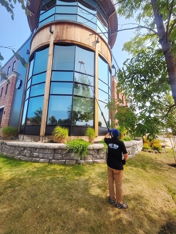Window cleaner reaching high windows of a commercial building in PEI